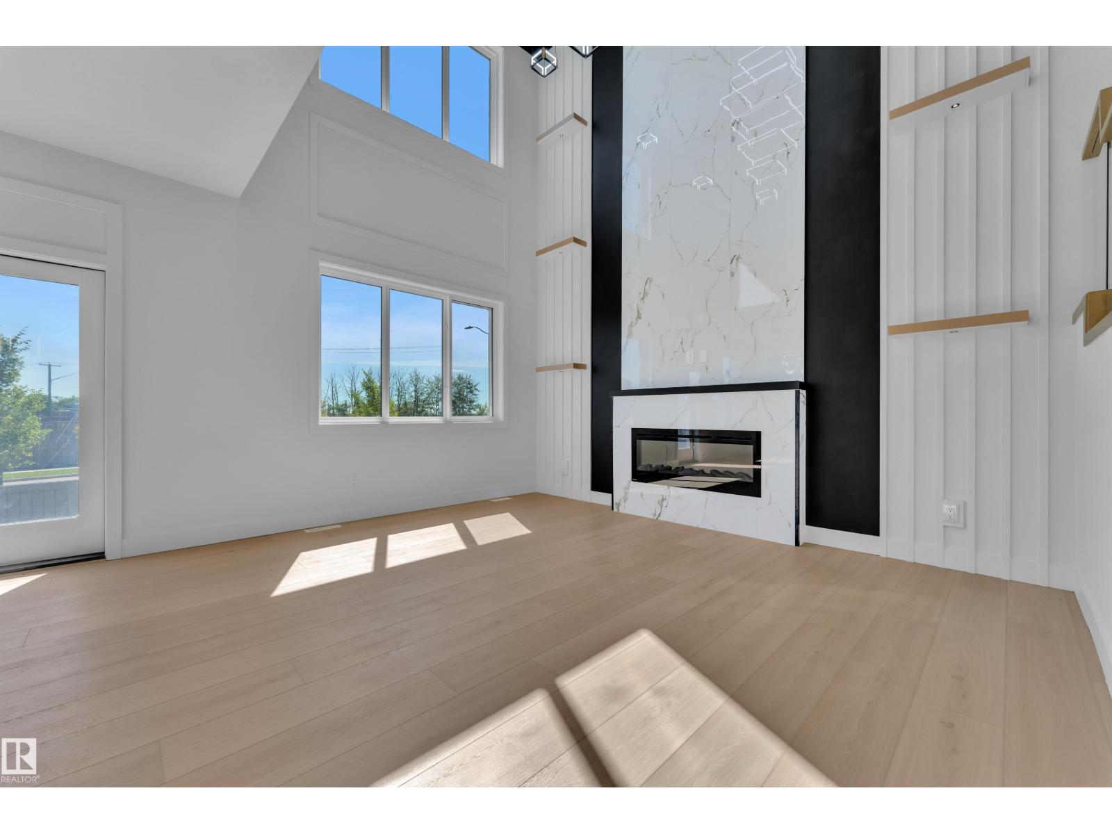Representative open-to-above great room with fireplace feature wall, at this finish level